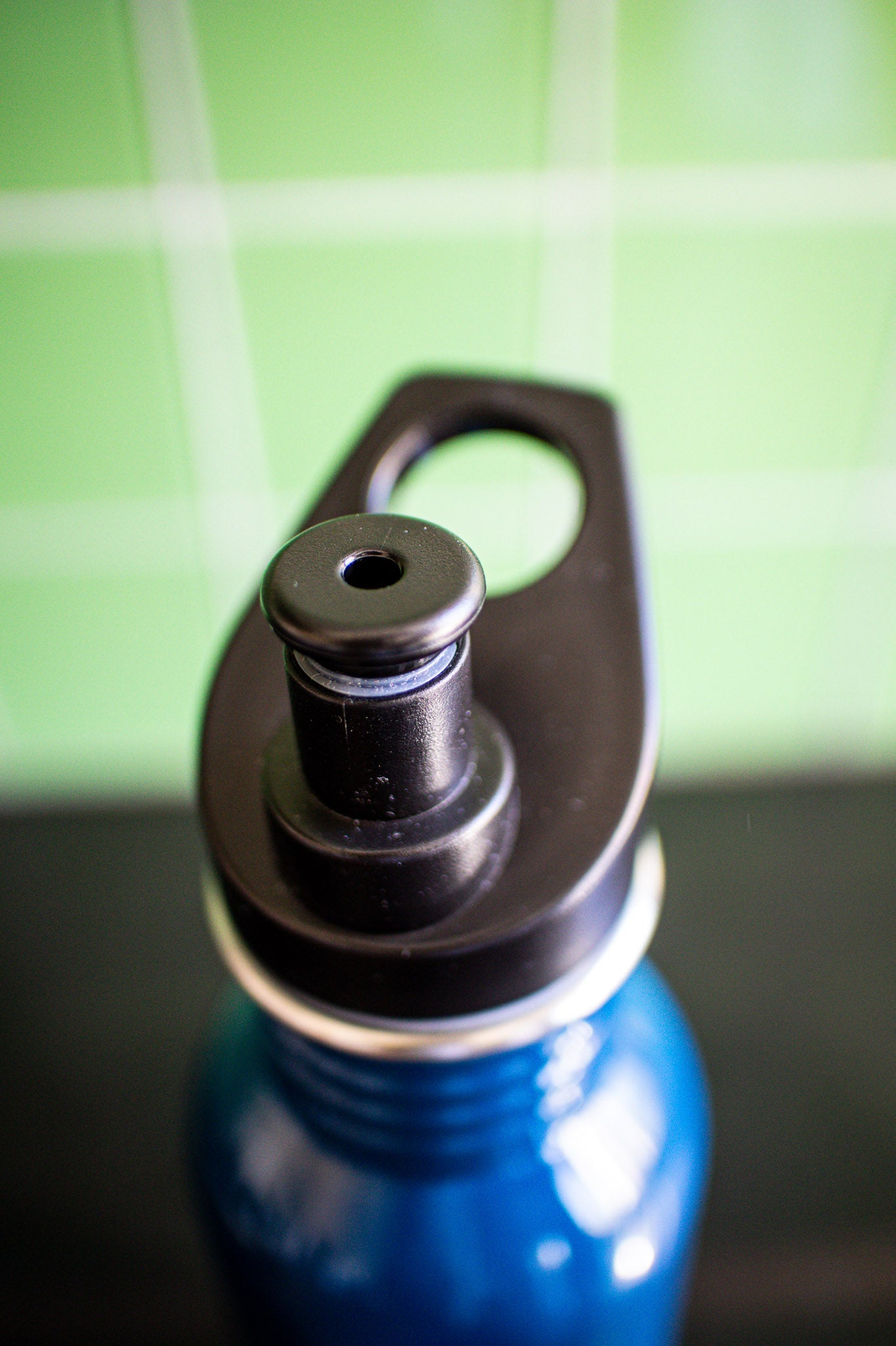 Top view of the navy RMIT bottle showing the black cap and a partial glimpse of the navy bottle body. Available at the RMIT Store.
